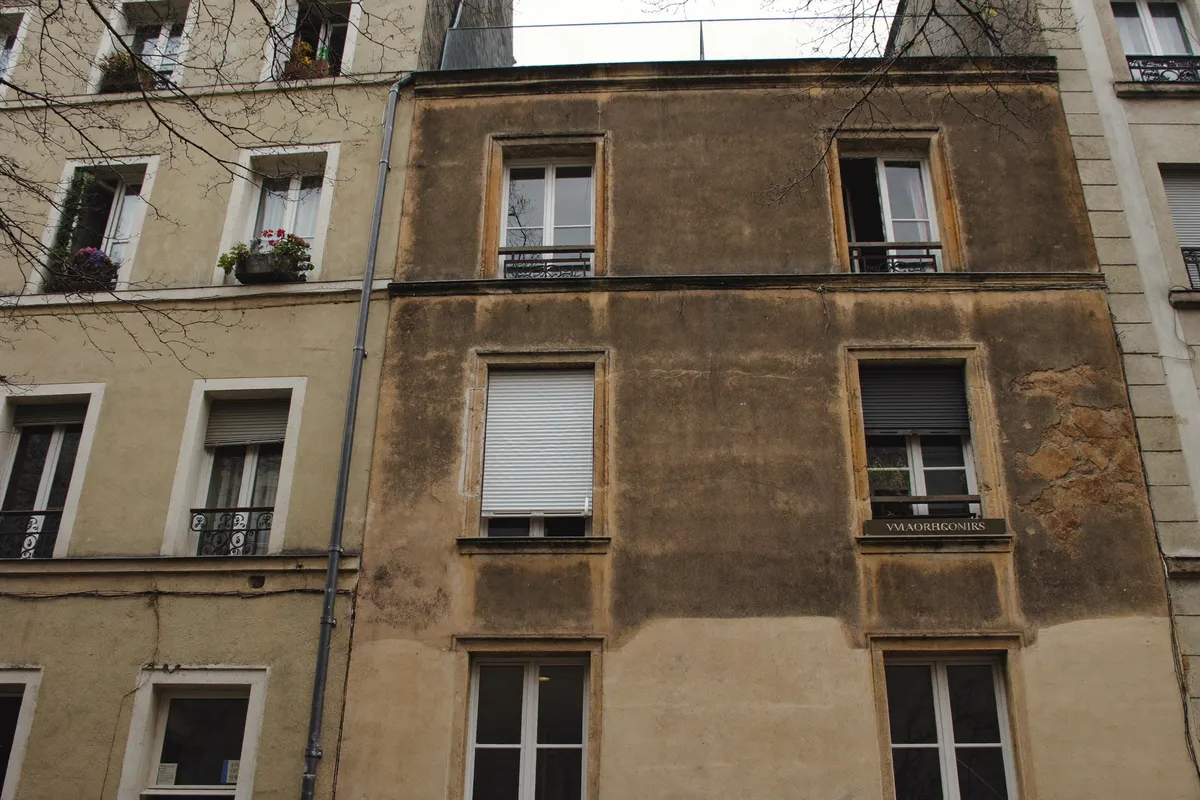Façade d'un immeuble ancien et usé du 20e arrondissement de Paris