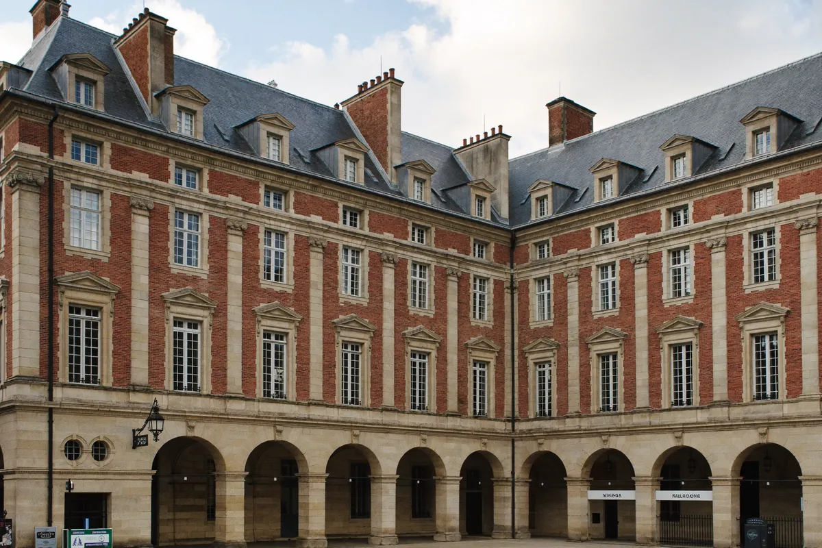 Façades à arcades en brique et pierre de la place des Vosges dans le Marais, 4e à Paris