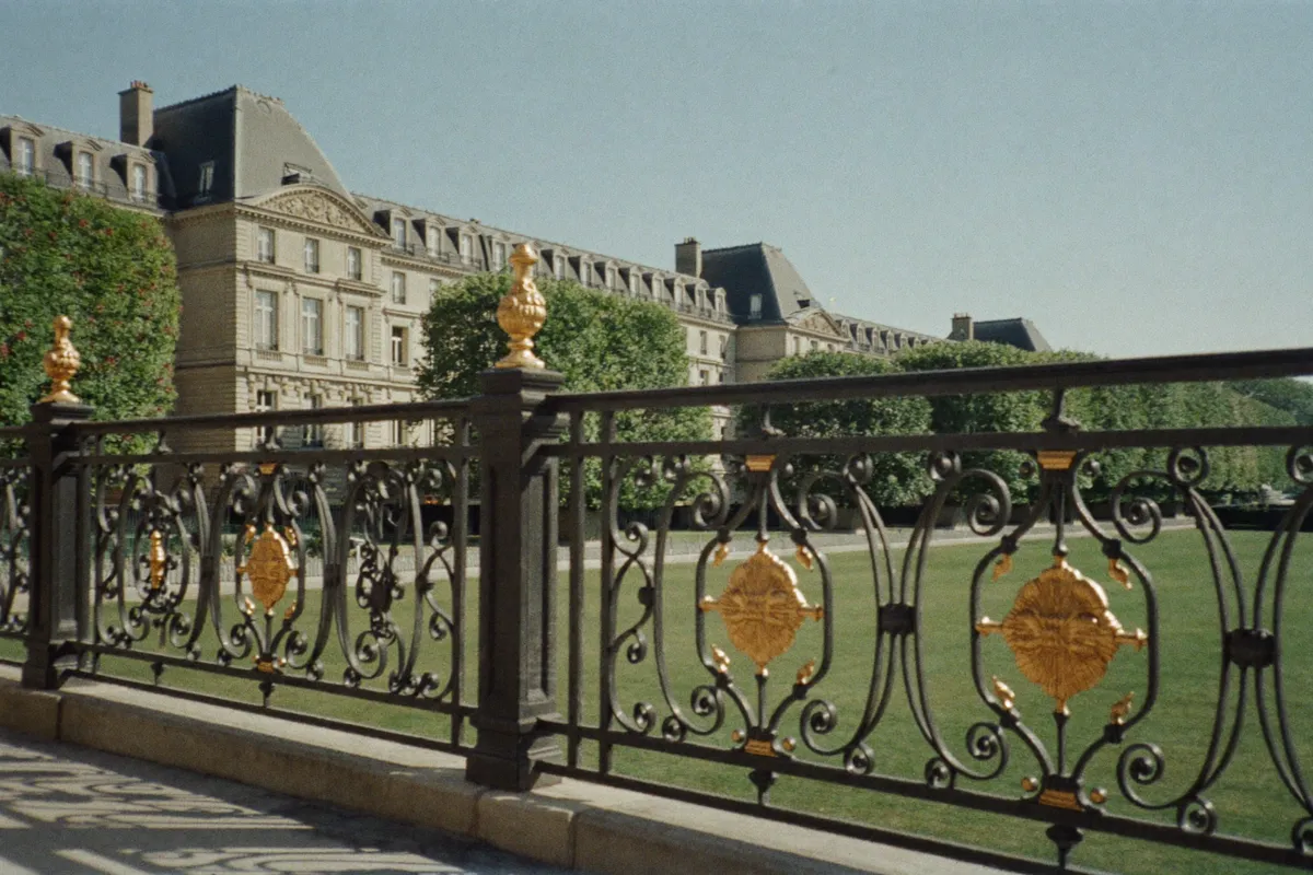 Grilles dorées du jardin du Luxembourg devant des immeubles classiques, 6e à Paris