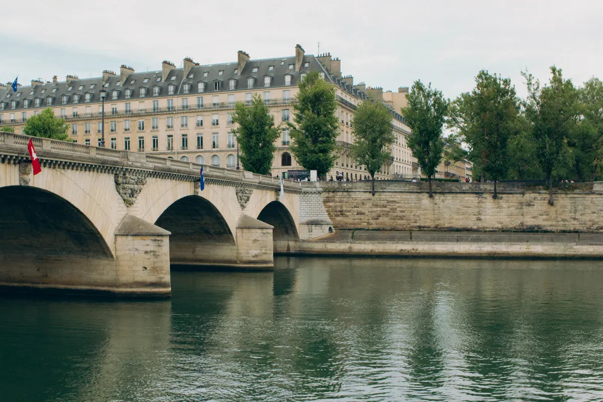 La Seine à Paris, un pont de pierre en arc et les quais bordés d'immeubles