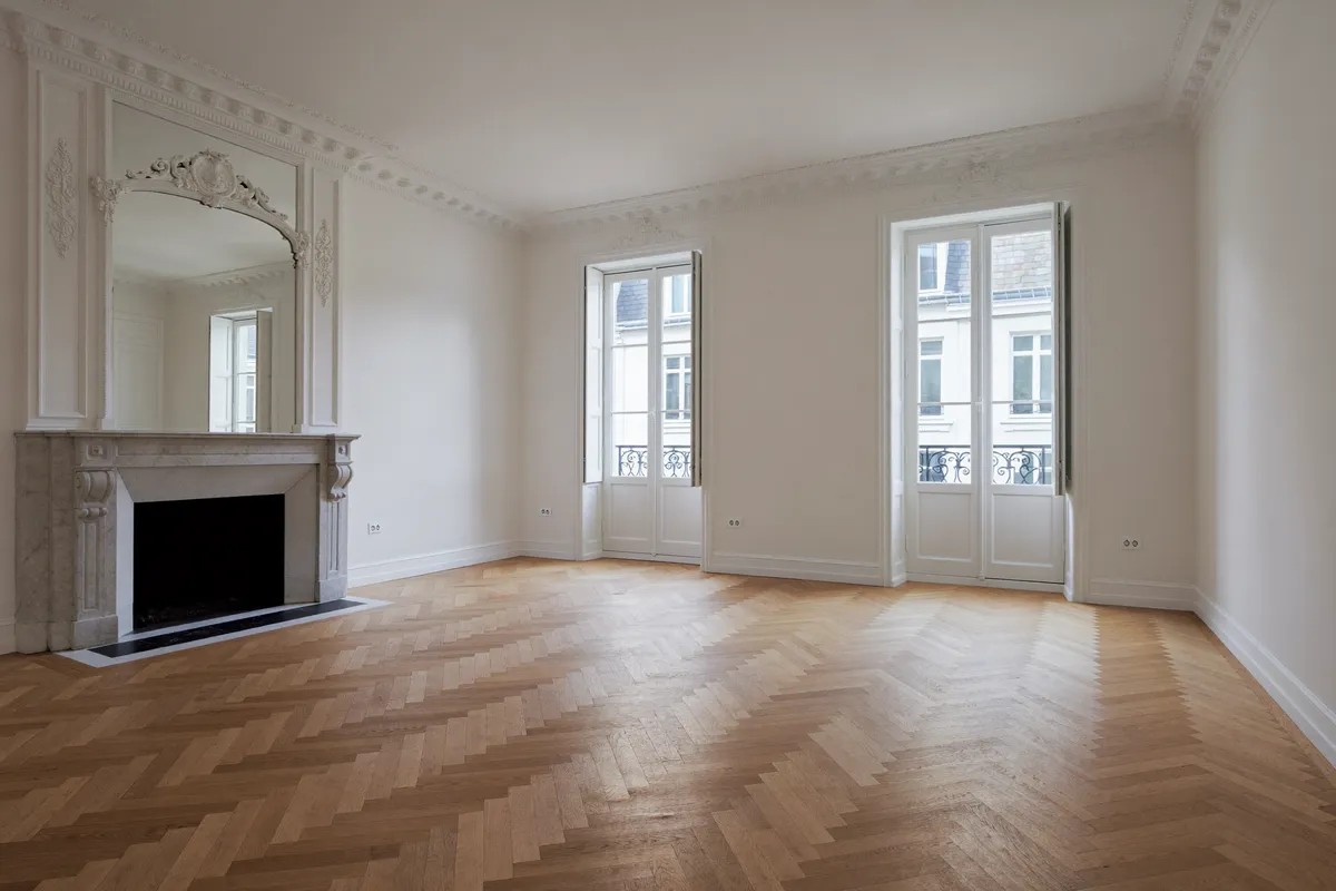 Appartement parisien lumineux à vendre, parquet à chevrons et cheminée en marbre